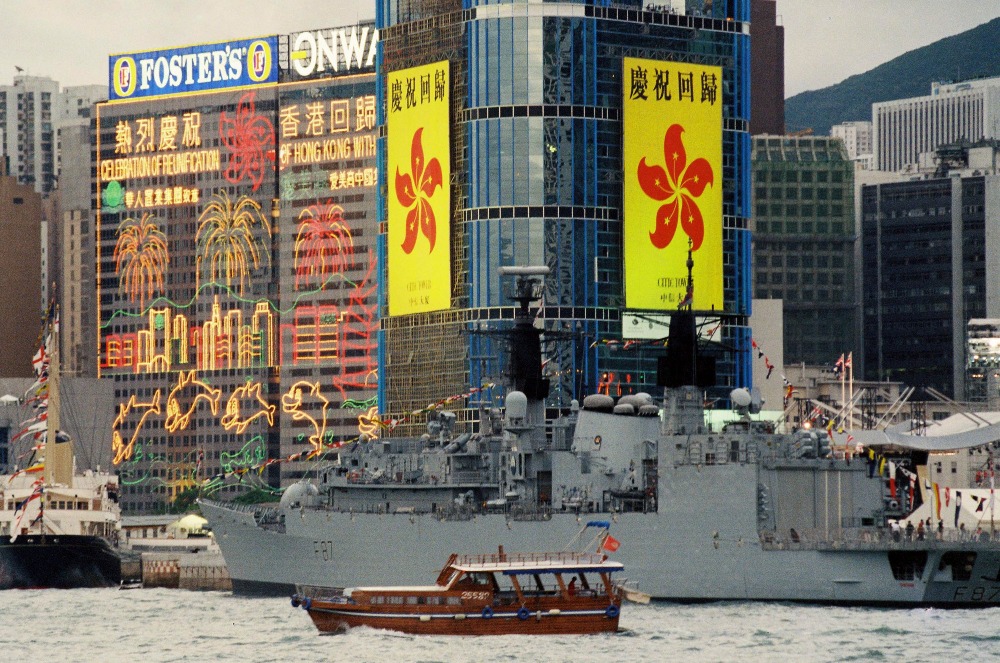 1997年6月30日，英軍軍艦在香港維多利亞灣準備接走撤離英軍，軍艦後是「熱烈慶祝香港回歸」的霓虹燈和標語。