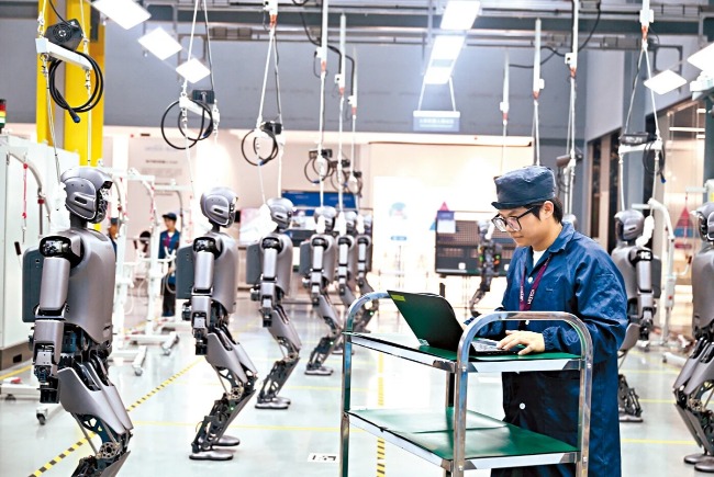 加速高水準科技自立自強，引領發展新質生產力，是「十五五」規劃的重點。圖為工人正在檢查工業版人形機器人。