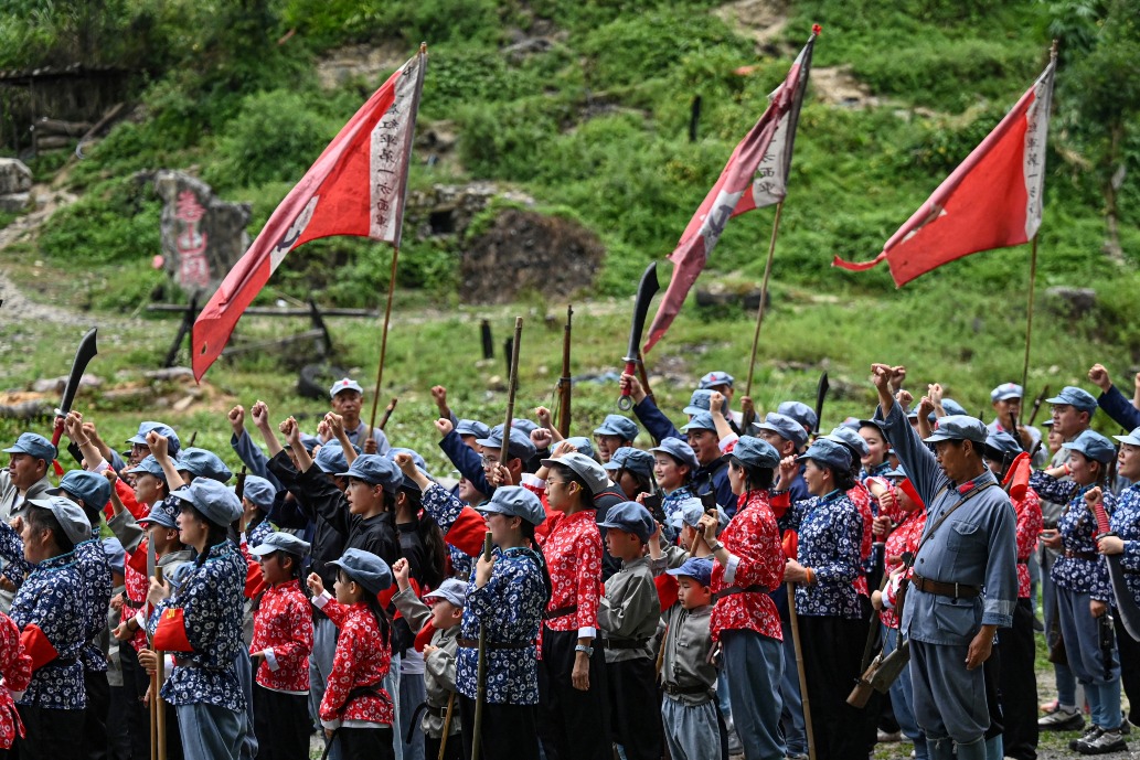 遊客參與婁山關戰鬥情境重演。 貴州遵義婁山關戰鬥情境重演中,身穿紅軍制服及年代服飾的演員與遊客揮動道具武器和紅旗。