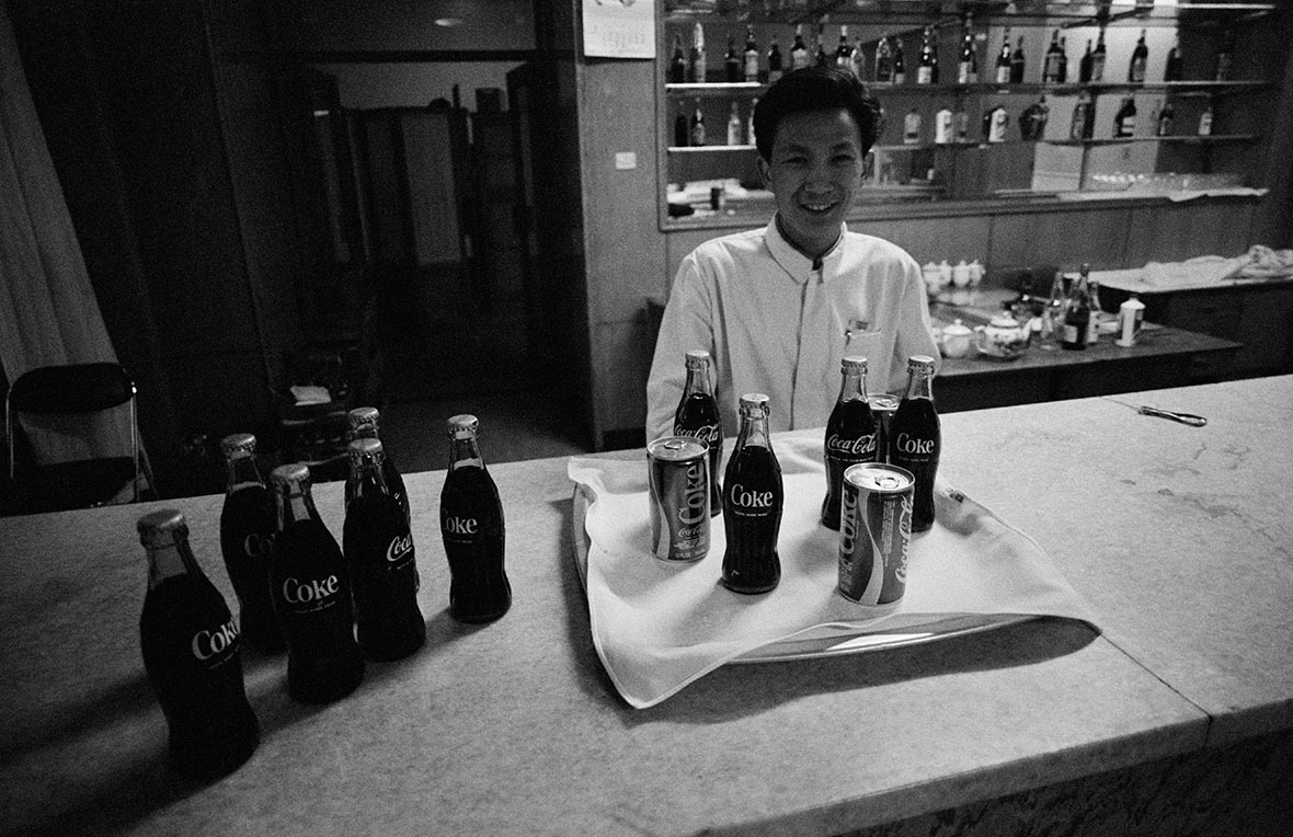 1979年2月，可口可樂進入中國市場不久，一名酒吧侍應把瓶瓶罐罐可樂排列，吸引客人購買。(圖片來源：Getty)