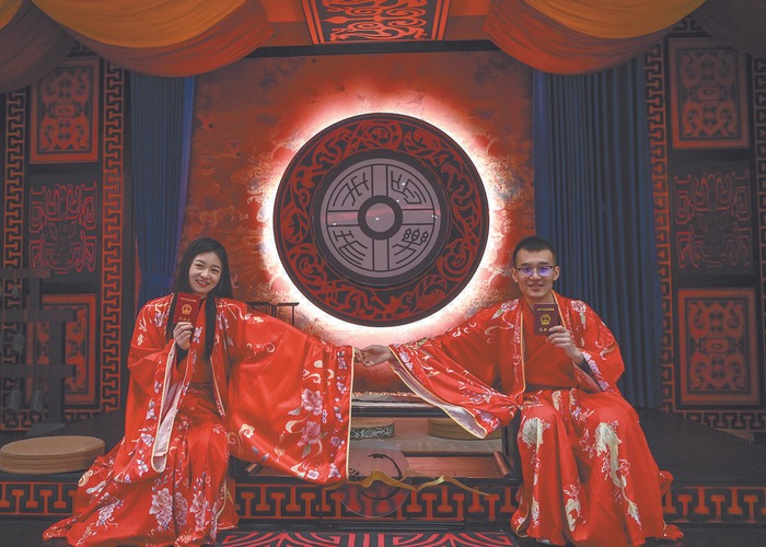 西安未央區開設首個漢文化沉浸式婚姻登記處，一對新人身穿漢服在展示結婚證。