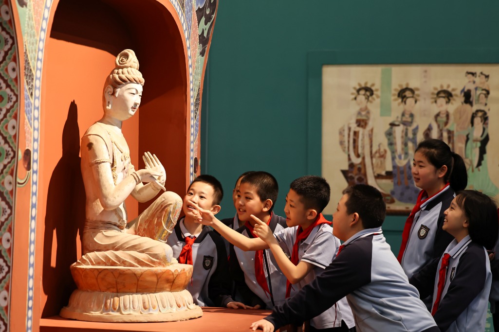 2026年5月18日適逢國際博物館日，學生到敦煌研究院蘭州敦煌藝術館參觀，在一尊佛像展品前開心觀摩研究。