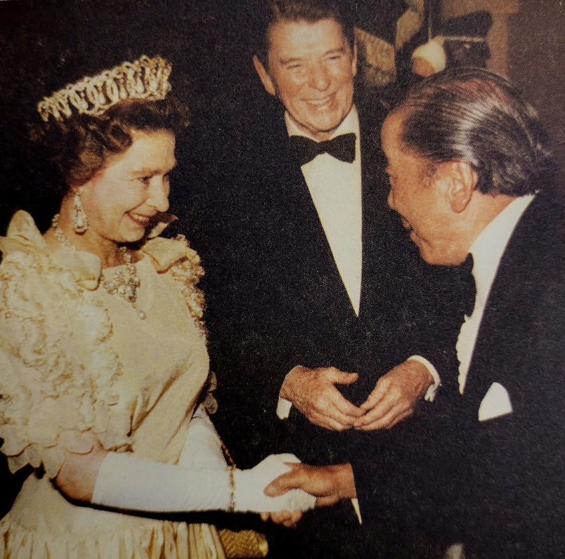 包玉剛作為世界船王，曾經會見多位國家元首，並建立起密切關係。圖為包玉剛（右）1983年在美國總統列根（中）陪同下，在宴會上與英女王伊利沙伯二世（左）握手。（圖片來源：《我的爸爸包玉剛》）