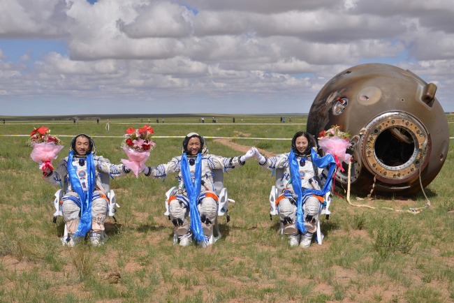 張曉光（左）和聶海勝（中）、王亞平（右）完成神舟十號任務，順利返回地球。