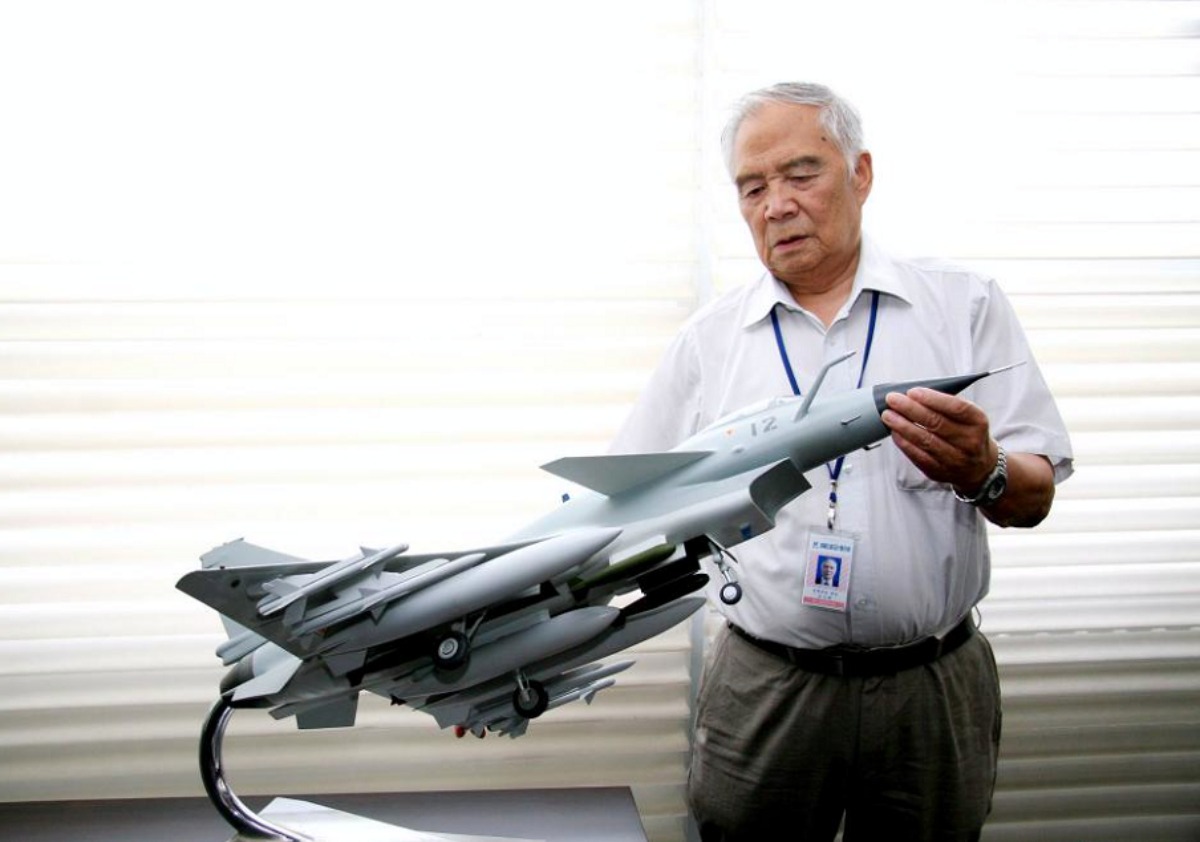 The picture shows Song Wencong with a model of the J-10.
