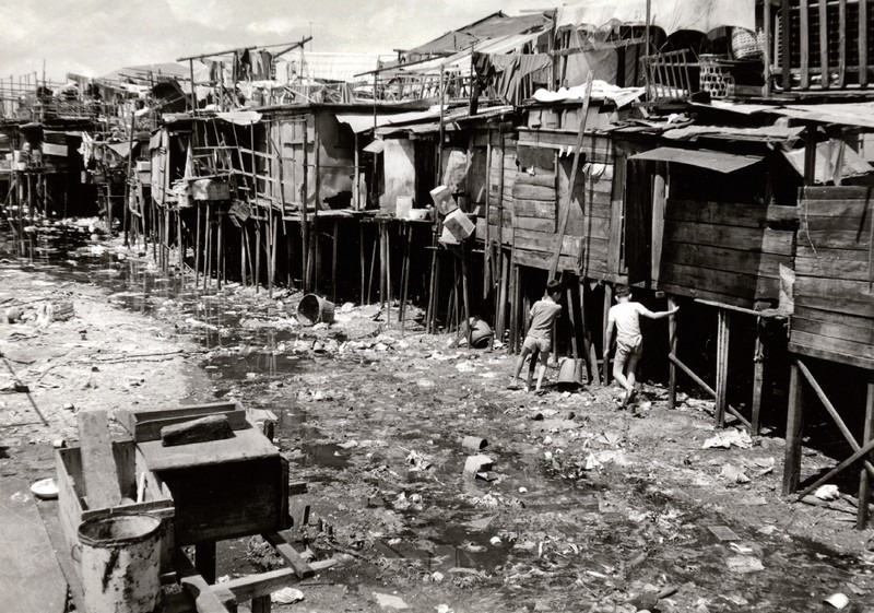 筲箕灣的陸上及海邊木屋區，無水、無電，衞生環境差。圖片攝於1960年。（圖片來源：渠務處）