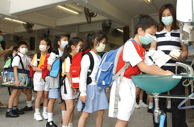 2003年3月沙士爆发,政府在3月29日宣布中小学等停课。5月12日起学生分阶段复课,学生须佩戴口罩上课,经常洗手。(图片来源:政府年报) 2003年3月沙士爆发,政府在3月29日宣布中小学等停课。5月12日起学生分阶段复课,学生须佩戴口罩上课,经常洗手。(图片来源:政府年报)