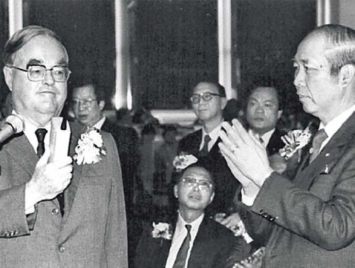 1986年聯交所開幕，標誌香港的4間交易所正式合併成為一間。圖為時任財政司彭勵治（左一）與聯交所主席李福兆（右一）主持開幕儀式。（網上圖片）