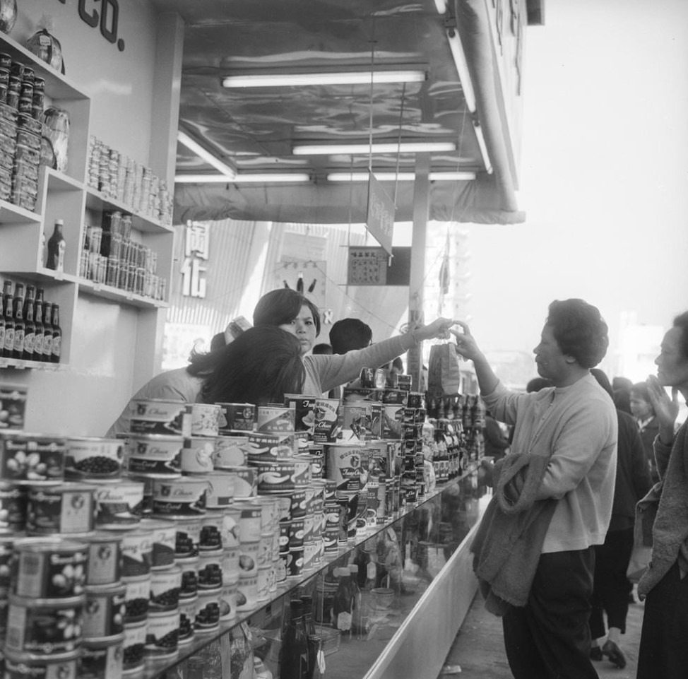 圖為1967年市民於第25屆香港工業出品銀禧展覽會同珍醬油罐頭攤檔買罐頭的情況。（圖片來源：香港記憶／政府新聞處）