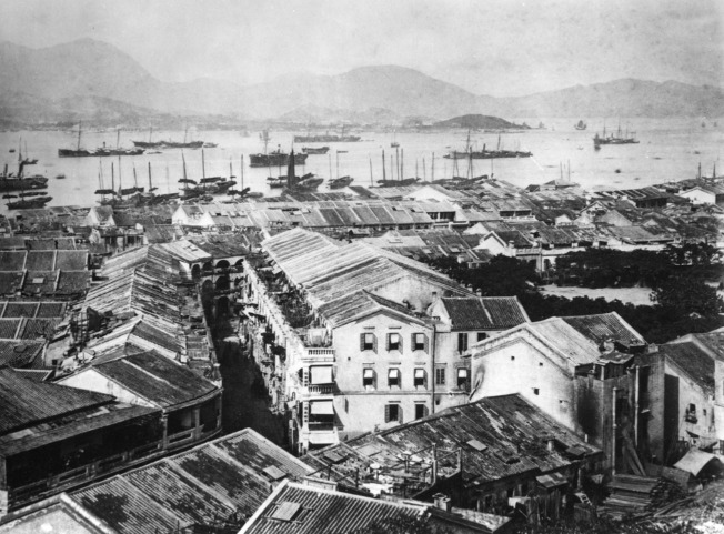 這幀圖片攝於1880年，遠景為維多利亞港。圖左方的街道為皇后大道西，圖右的水坑口如今已變成荷李活道公園。（圖片來源：香港記憶／香港大學圖書館）