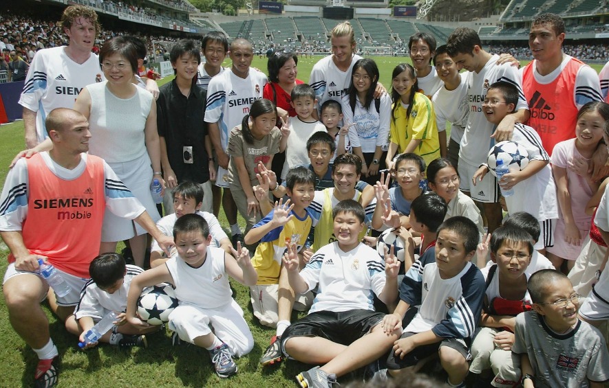 2003年香港經歷非典型肺炎後，政府為提振社會氣氛及改善經濟，推出多項活動，包括重金邀得西班牙勁旅皇家馬德里的「6條Ace」陣容在香港大球場獻技，哄動全城。這幀球星薈萃的大合照，記錄了球迷們珍貴一刻。（圖片來源：Getty）