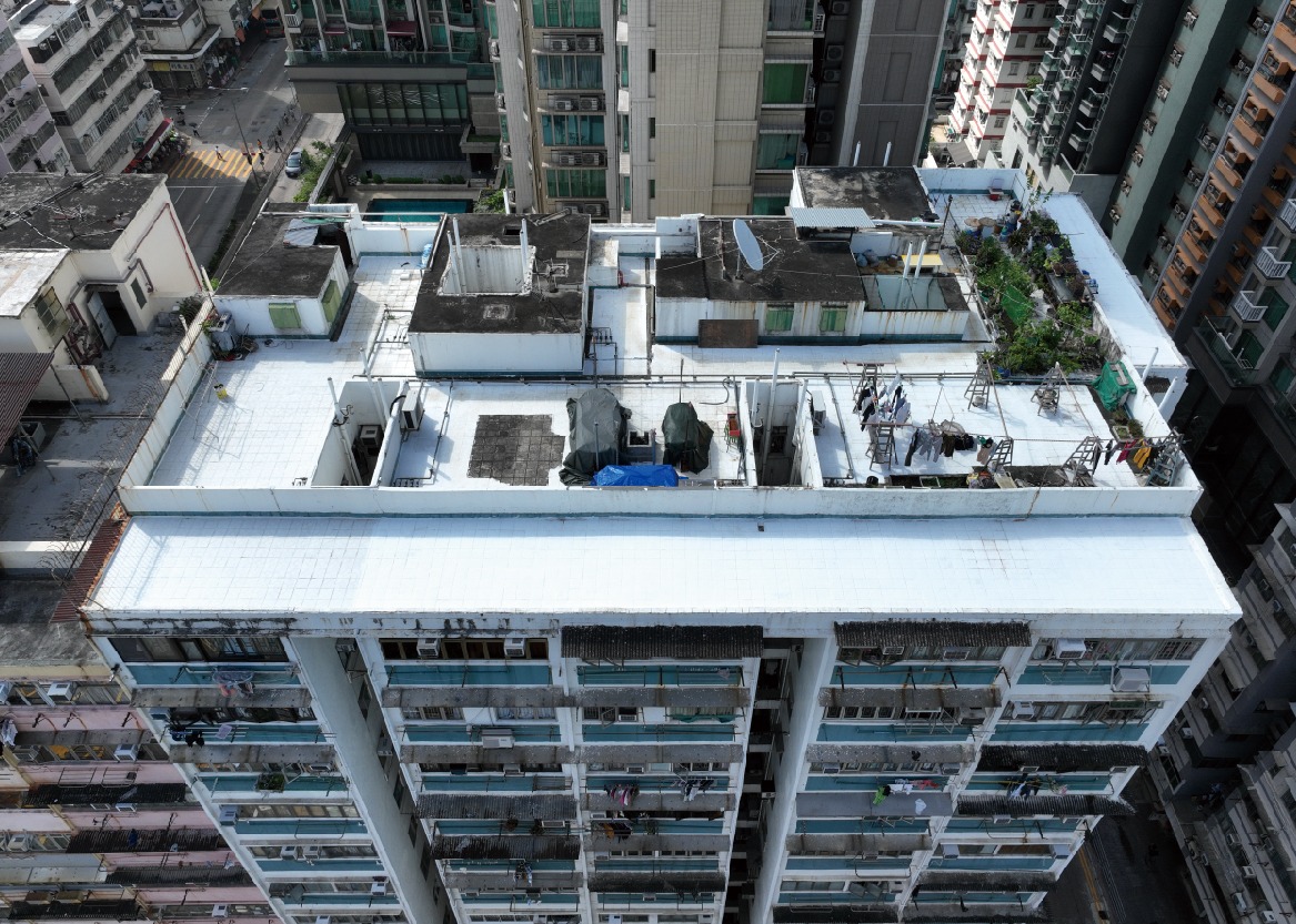 深水埗永明大厦是其中一幢大厦的天台涂上白色的制冷涂料，达到降温效果。