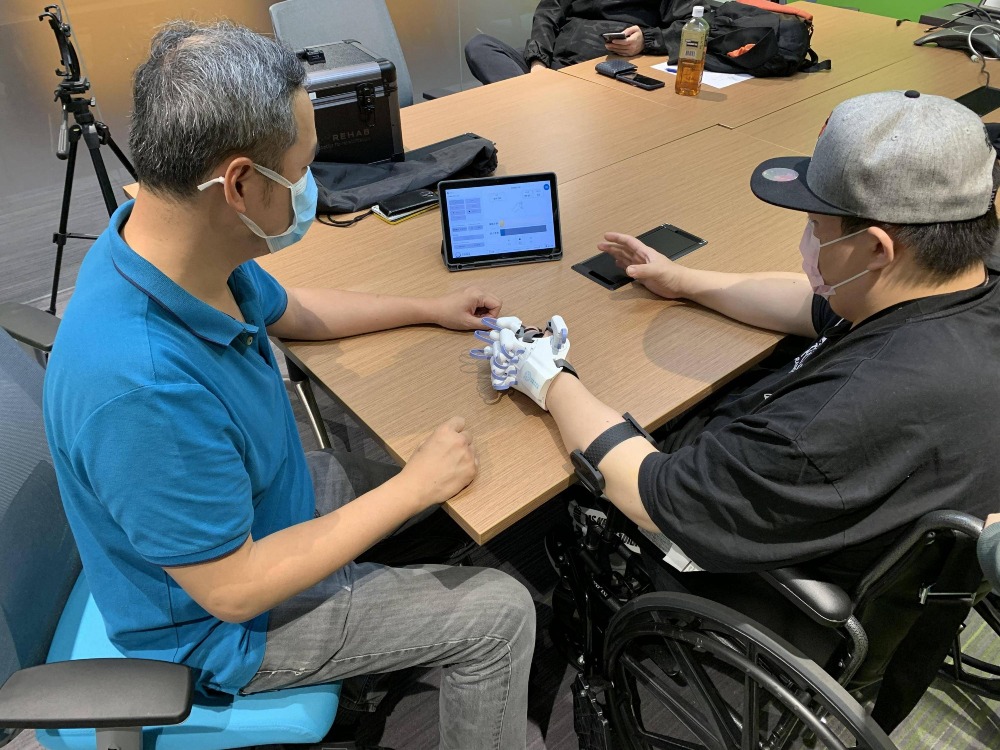 中風患者在治療師的協助下，試用HandyRehab家用版復康機械手。