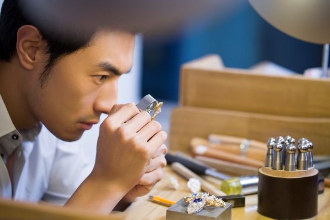 Diamonds are the hardest natural mineral. Besides being used as ornaments, they also have wide-ranging industrial applications. The picture shows a craftsman inspecting a diamond intended for use as jewellery.
