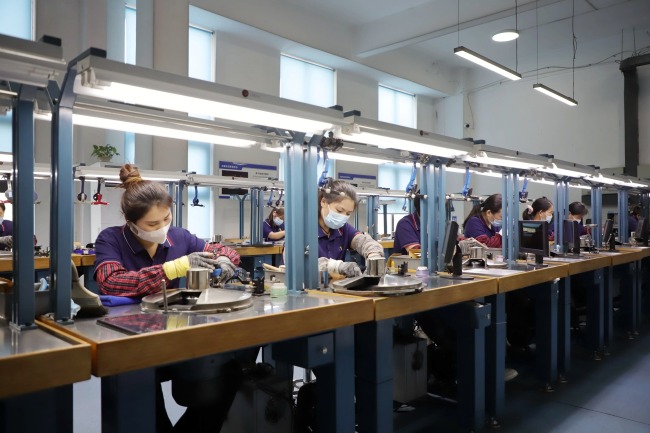 The output of lab-grown diamonds from Zhecheng accounts for 60% of the national total. Pictured are local workers polishing rough lab-grown diamonds.
