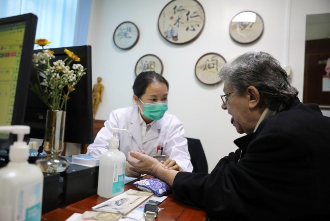 The picture shows a Belgian seeing a traditional Chinese medicine doctor in Beijing.