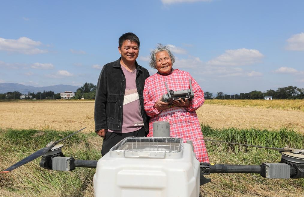 戴淑英在孫兒王甜甜指導下，操作植保無人機。
