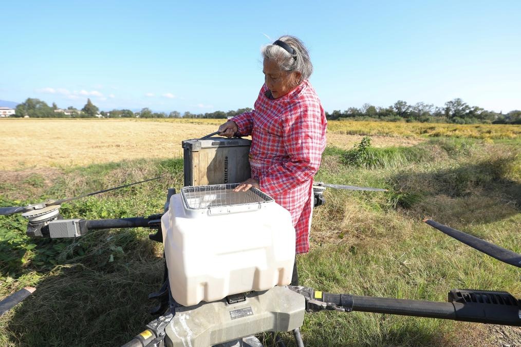 戴淑英搬動植保無人機約30斤重的電池作更換