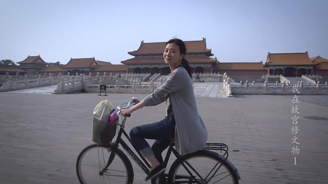 紀錄片《我在故宮修文物》中，年輕女文物修復師在故宮太和殿廣場上踩單車。
