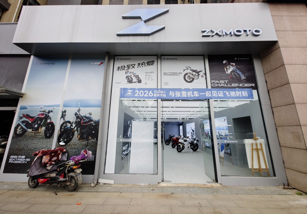 張雪 張雪機車武漢店,店前掛着「與張雪機車一起見證飛馳時刻」的藍色橫幅。