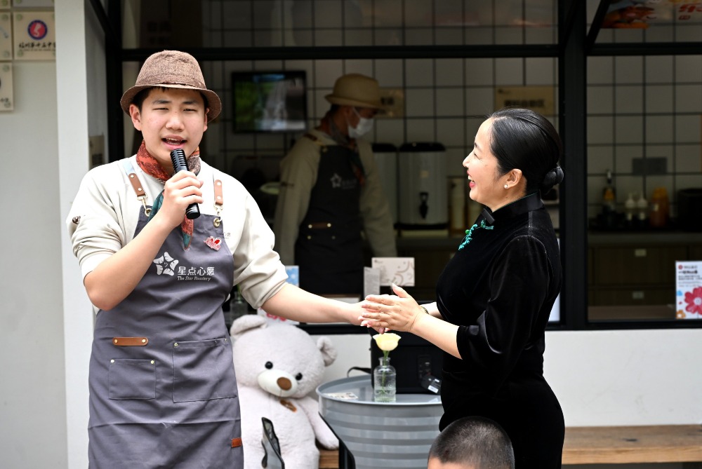張秀麗和兒子「旺旺仔」 2026年3月29日,「旺旺仔」為顧客獻唱,媽媽張秀麗在旁邊為他加油。
