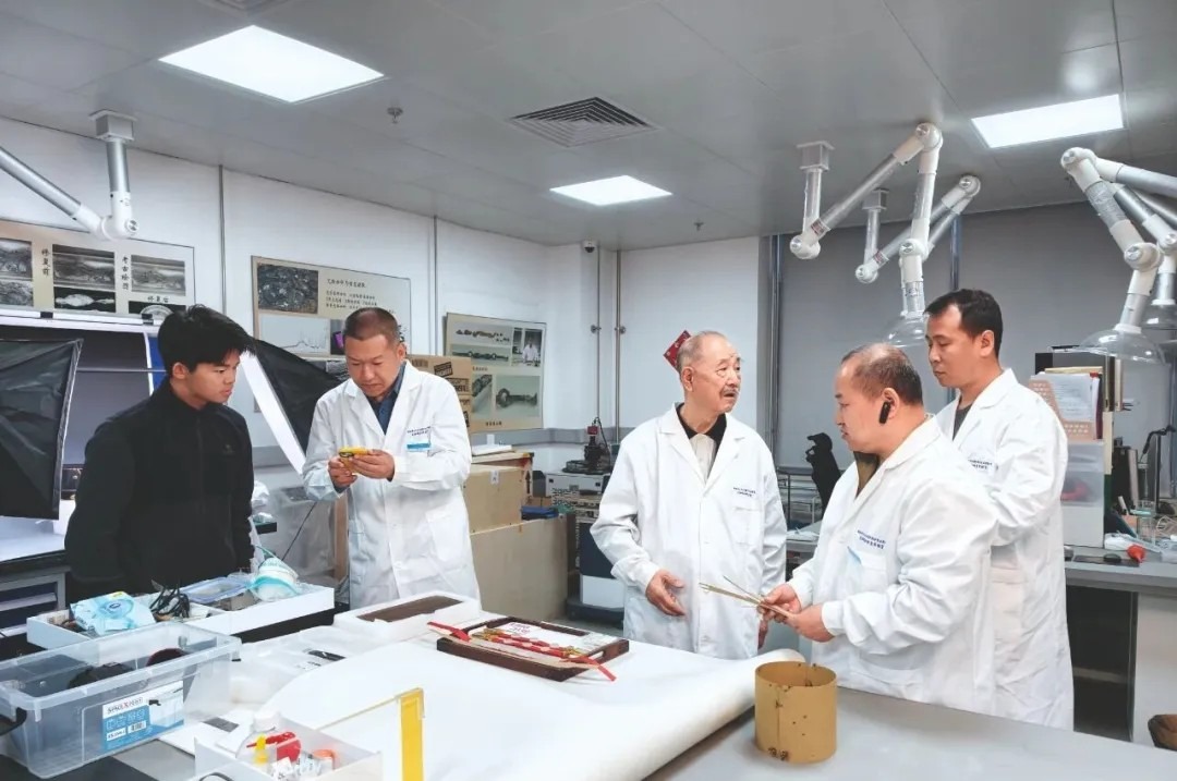 白榮金(左三) 資深文物修復專家白榮金(左三)正跟同事討論文物修復事宜。