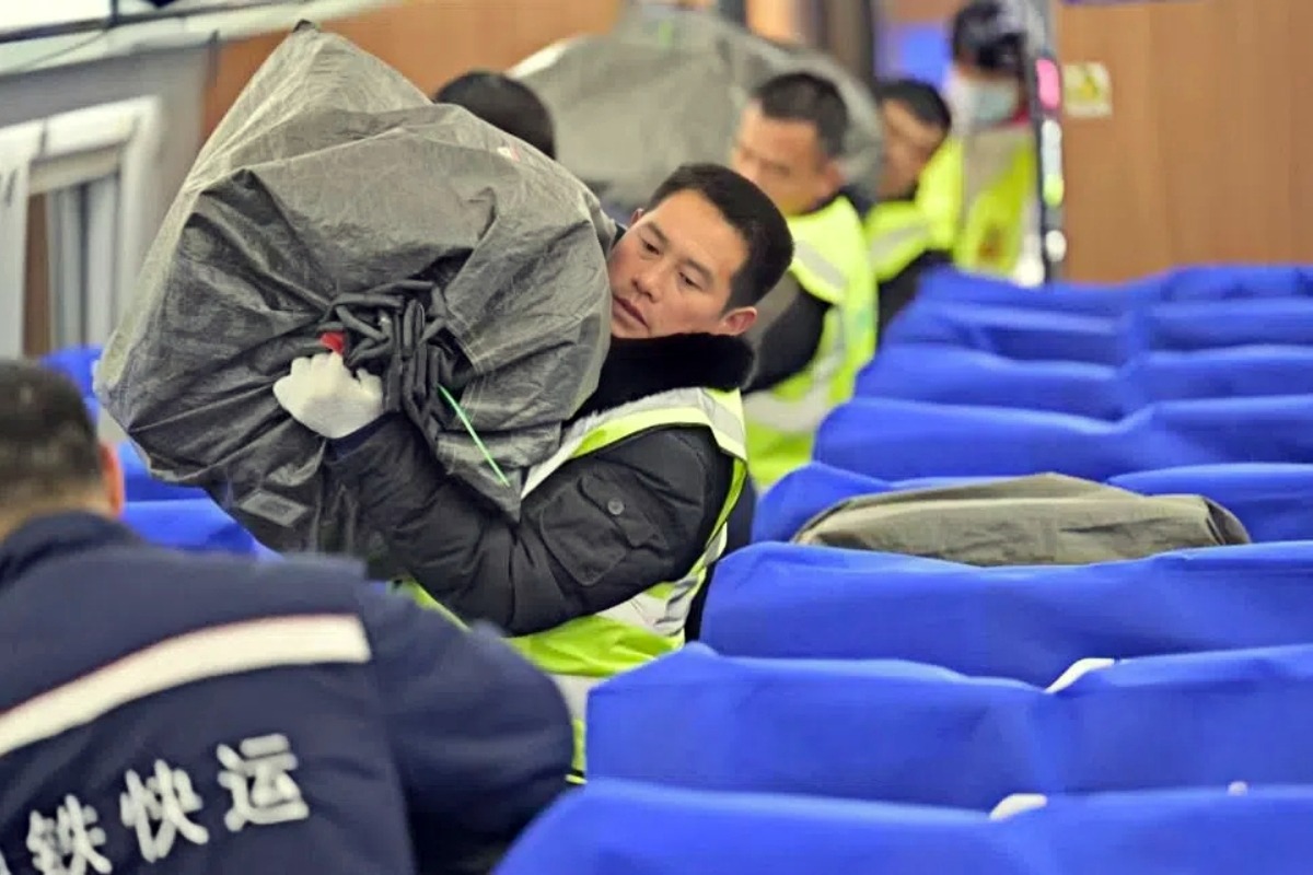 The picture shows staff loading courier mailbags onto a dynamic inspection confirmation train. 