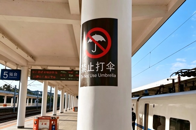旅客看到「禁止打傘」標誌，應主動收起雨傘。