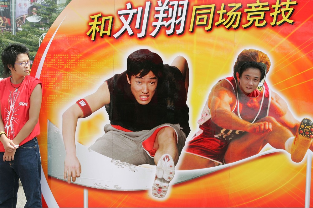 2005年，一名男子在上海體育場的廣告牌上與劉翔「合照」。（圖片來源：Getty）