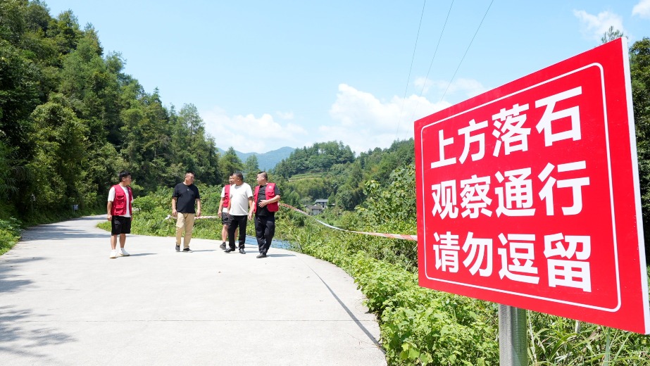 重慶龍潭鎮新田村的幹部和網格員對當地地質災害隱患點進行排查，並設立警戒線。