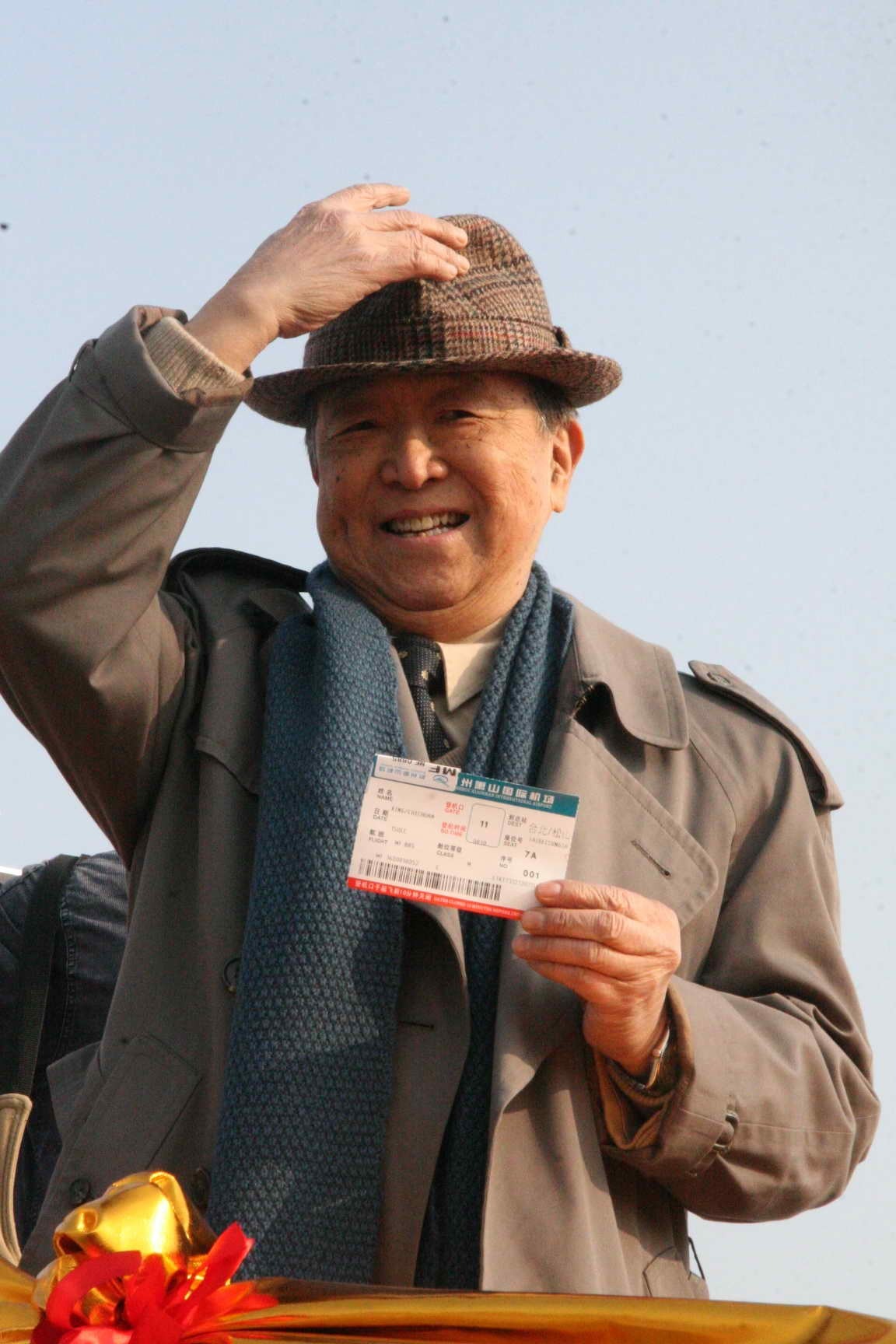 76歲的金先生拿到了杭州到台灣首發直航班的一號票，並告訴記者「作為第一號乘員，我此刻非常激動。」臨登機前，金先生還不忘揮舞着這張特殊的機票，向前來送行的人致意。（圖片來源：中新社）