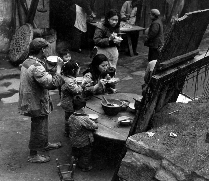 1950年代,一個家庭在街上吃飯。