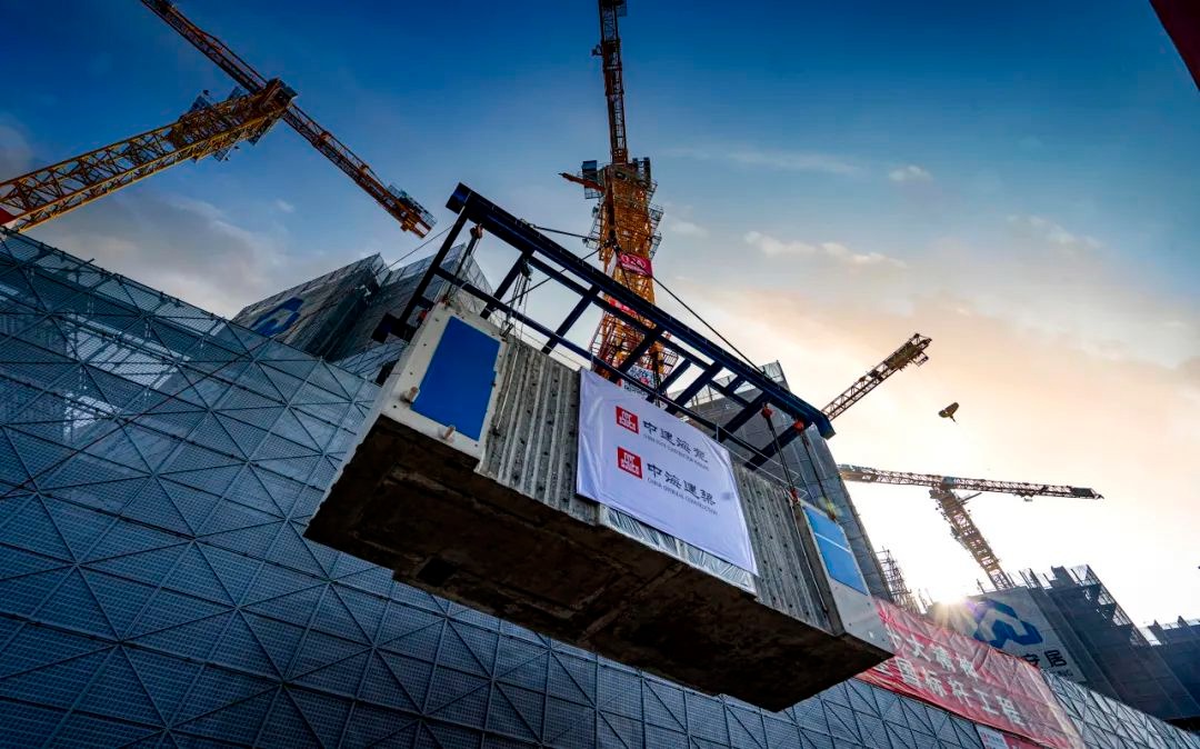 The picture shows modules built in a factory being transported to a construction site for assembly and connection.