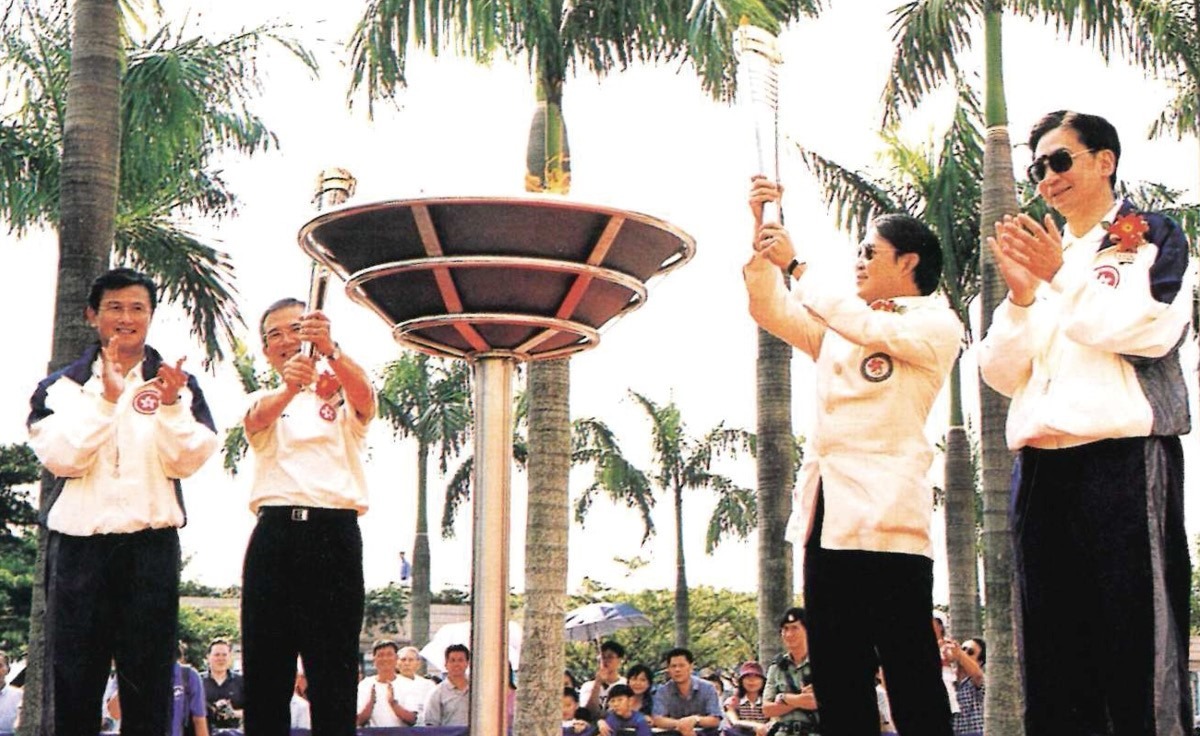 2001年的九運會在廣東舉行，時任民政事務局局長林煥光（左二）和九運會香港代表團籌備委員會主席霍震霆（右二）在尖沙咀文化中心廣場燃起全運會聖火。