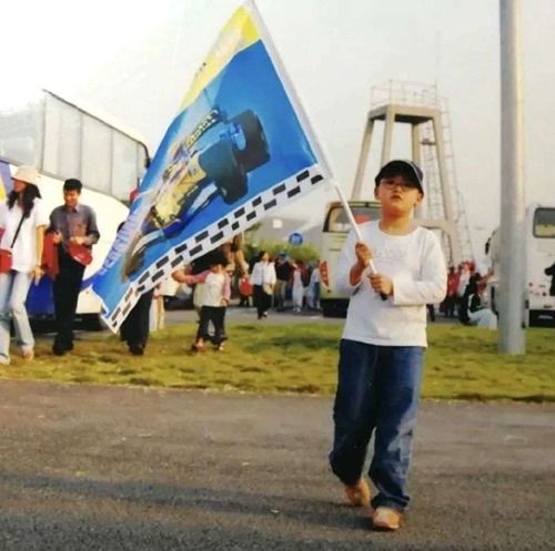 這是周冠宇小時候在上海觀看F1大賽車時，揮舞着阿朗素的旗幟，想不到如今他有機會與自己的偶像同場較量。