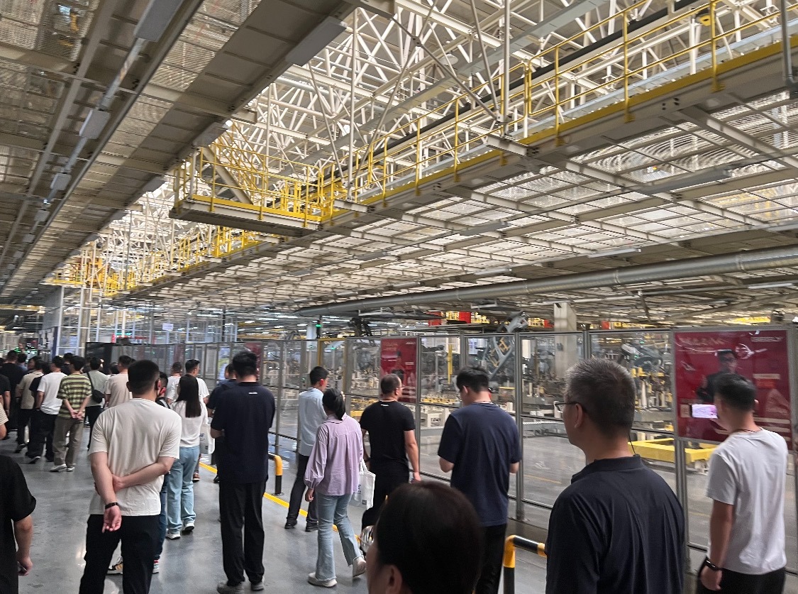 在吉利汽車西安製造基地，學生和家長參觀無人流水線。