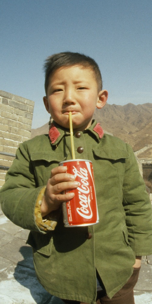 當代中國-改革開放-這是一張非常有名的照片，拍攝年份是1979年。據說相中男孩是改革開放後中國第一個喝可口可樂的平民。有指他手上的可口可樂是攝影師James Andanson偷偷帶進中國，然後在長城送給男孩，好讓他能拍照。