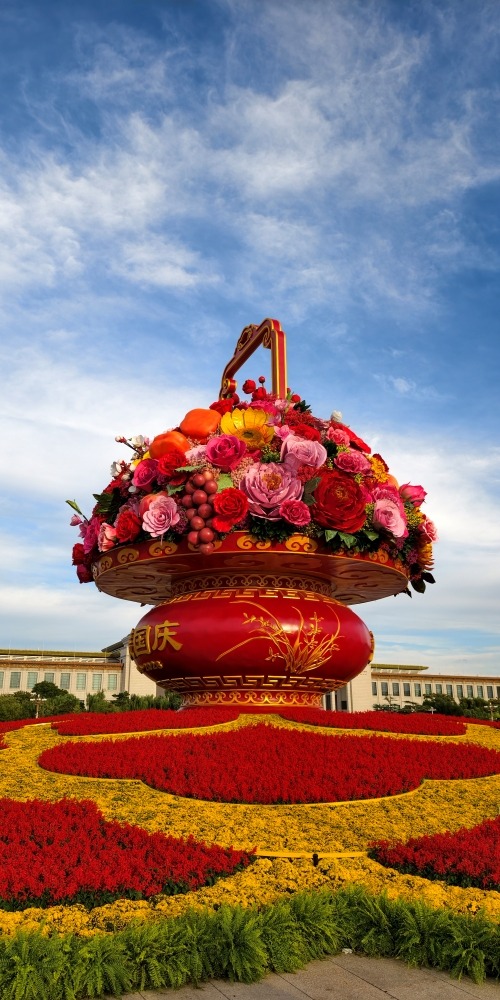 天安門廣場「祝福祖國」巨型花果籃全景，籃身寫有「祝福祖國，1949-2026」，前景為國慶花壇，背景可見天安門城樓與藍天白雲。