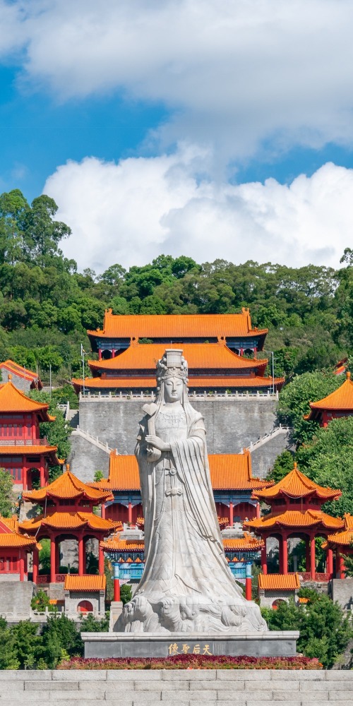 南沙天后宮位於南沙大角山東南麓，遠看像一座宮殿。門前先有一座典雅的牌坊，四根立柱四句對聯，橫樑刻上「南沙天后宮」，旁邊還有龍形浮雕，極具氣勢，殿前一座約5層樓高的天后像溫柔地震懾四方。